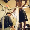 Biomedical engineer Adam Thrasher attaches electrodes to Adrian Morrison's paralysed right leg, in the hopes of getting it up to the same level of mobility as the left. Published in The Varsity, November 17 2003.
