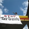 A demonstrator on top of a Shell gas station in London, which activists shut down for the day in protest of the oil company's activities in the Alberta tar sands. Published with the New Internationalist, May 21 2010.