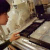 Grad student Amy Tong using robotic equipment to create 12.5 million strains of yeast in order to look at how the microbe's 6,000 genes interact with each other. Published in The Varsity, March 22 2004.
